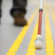 Blind pedestrian walking on tactile paving
