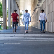 3 men walking on hallway
