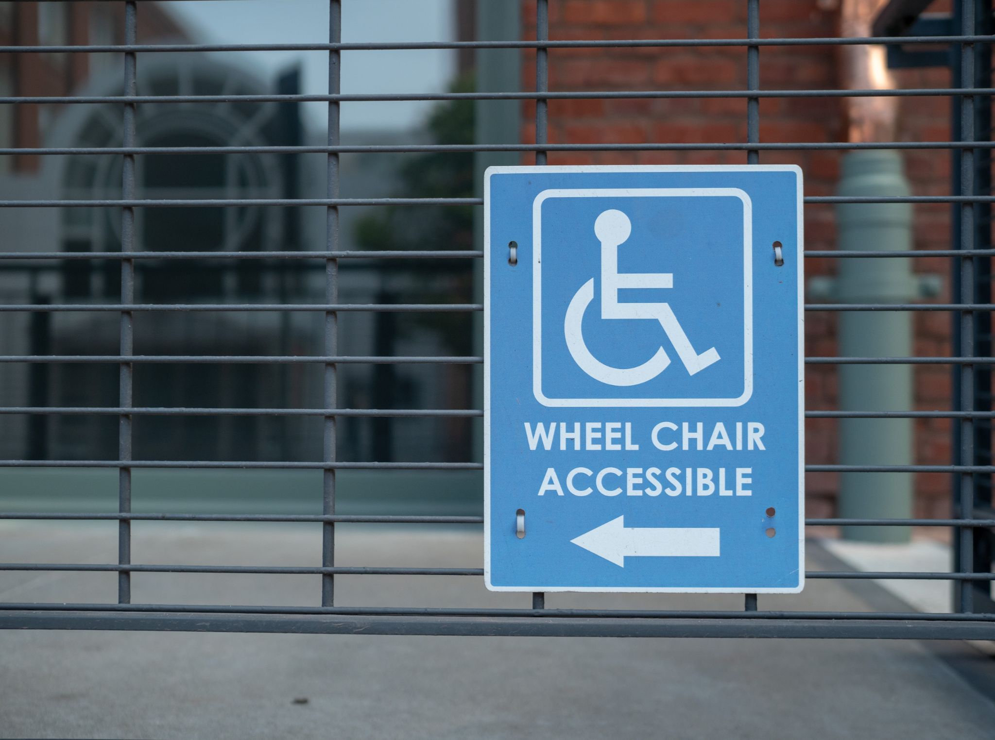 Handicap sign, wheel chair accessible logo pointing to left outdoor