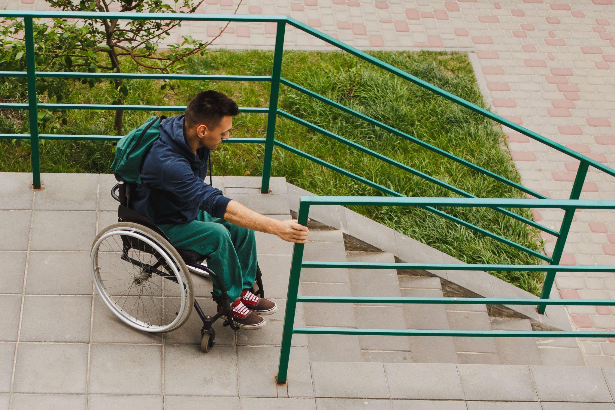 man in wheelchair approaching stairway