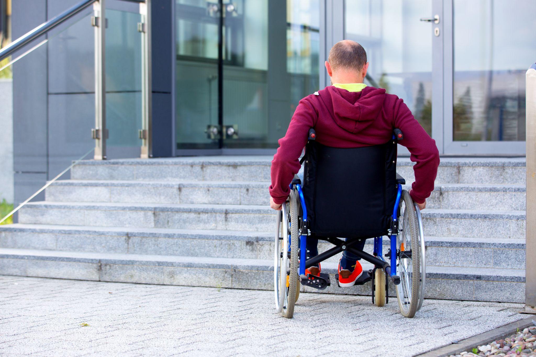 man in wheelchair approaching stairway
